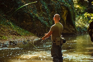 A fisherman fishing with fly fishing in the flowing stream